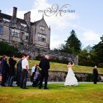 Bride playing golf to 18th green on her wedding day at Bovey Castle in Devon with hotel in the background