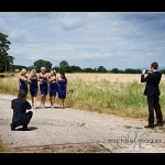 Guests photographing bridesmaids in fields at Somerset wedding