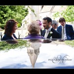 Somerset wedding photography of groom and church spire reflected in the wedding car roof.