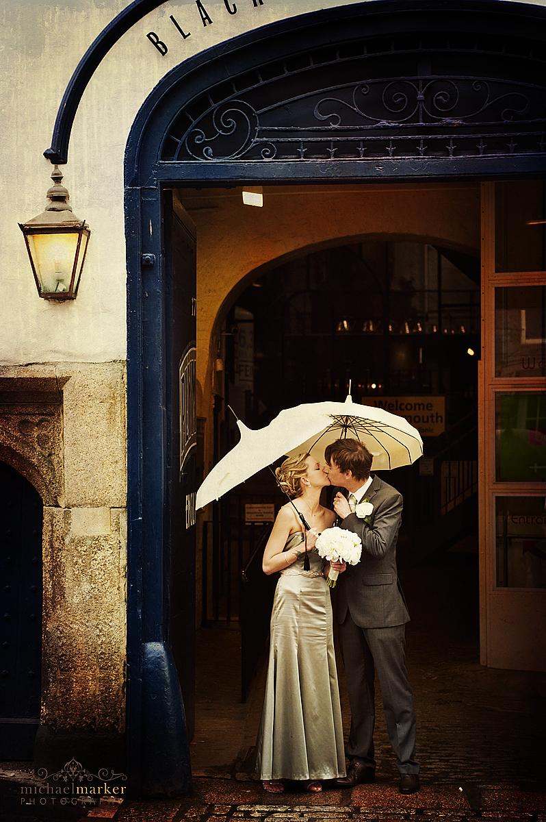 Wedding kiss outside Plymouth Gin Distillery