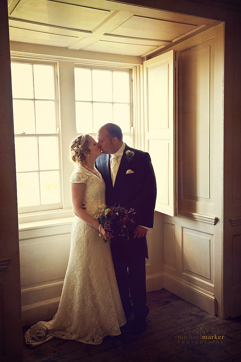 Falmouth wedding inside Pendennis castle. Bride and groom kissing