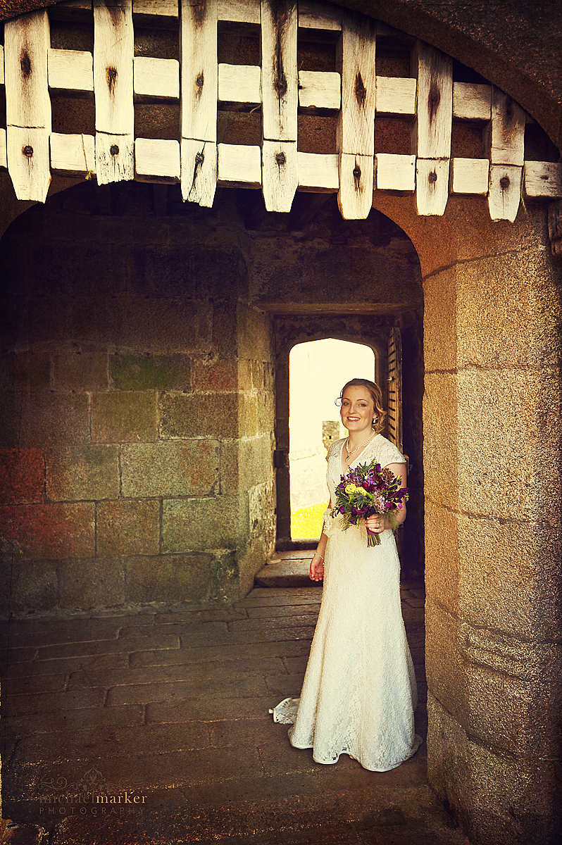 Bride outside Pendennis Castle with flowers for wedding in Falmouth