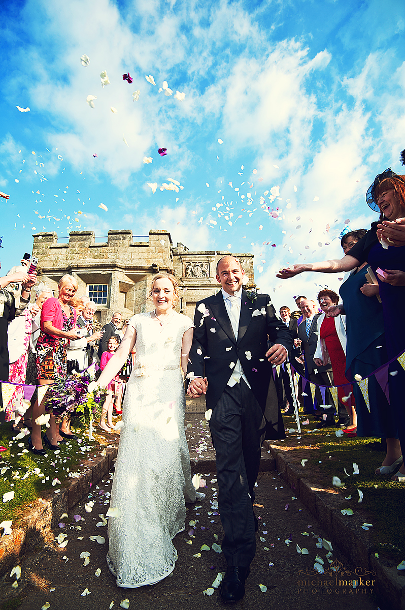 Pendennis Castle weddign - bride and groom walking through confetti