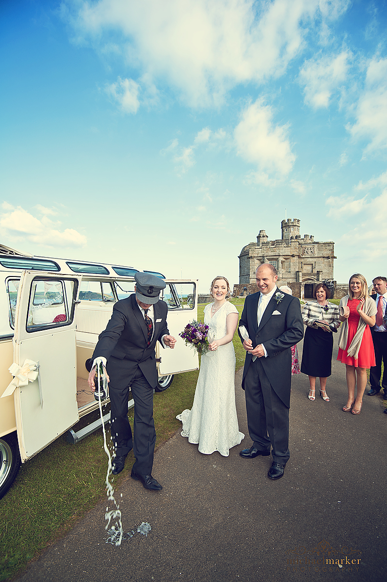 Falmouth wedding at Pendennis Castle opening the champagne for the bride and groom.