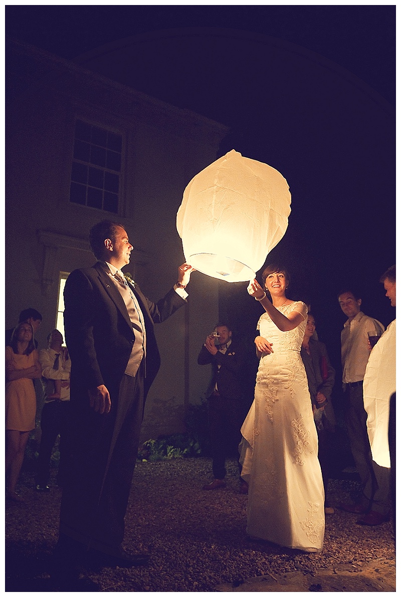 Bride and groom Lighting Chinese lanterns at North Devon wedding 