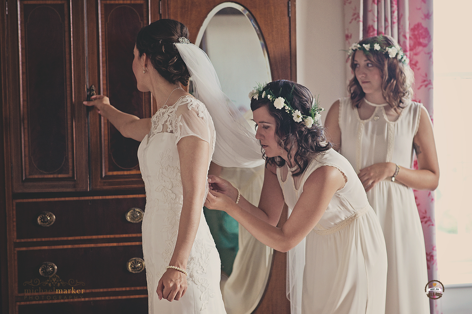Bridesmaid buttoning the wedding dress
