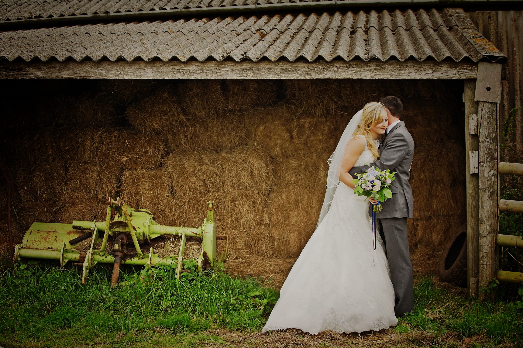Bride and groom kissing at barns at Corn Barn wedding in devon