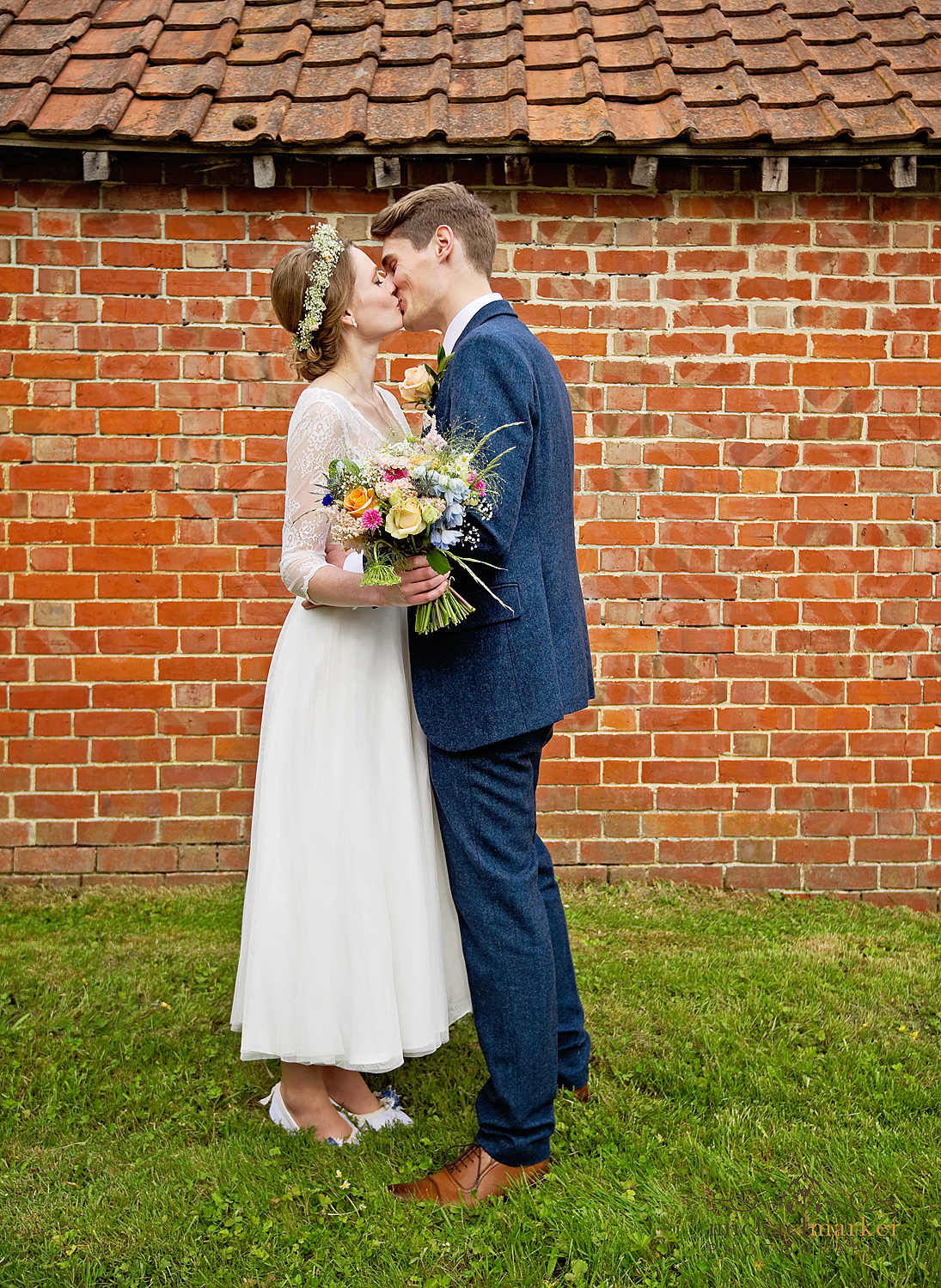 Bride and groom kiss at Wiltshire wedding in country village
