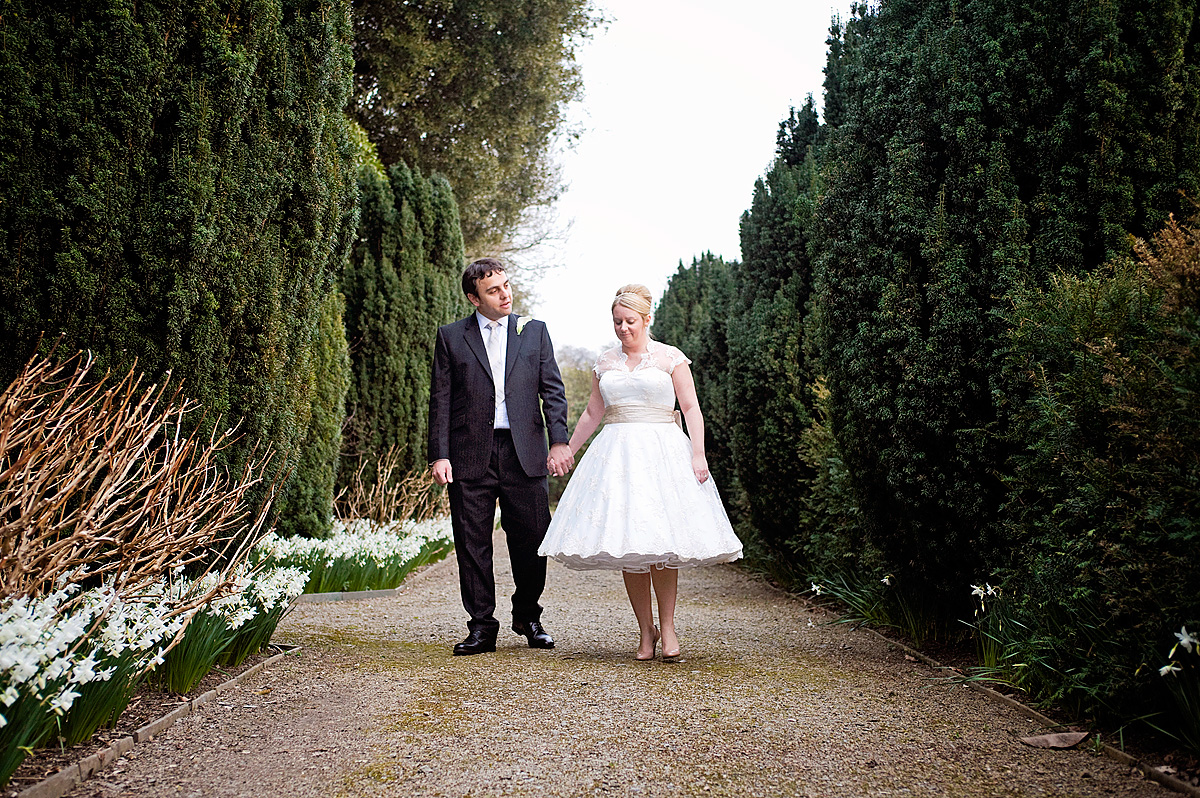 Bride and groom walking in formal gardens at Hotel Endsleigh in Devon