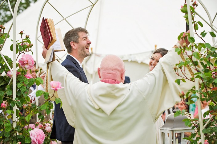 Groom and vicar celebrating the wedding in Devon