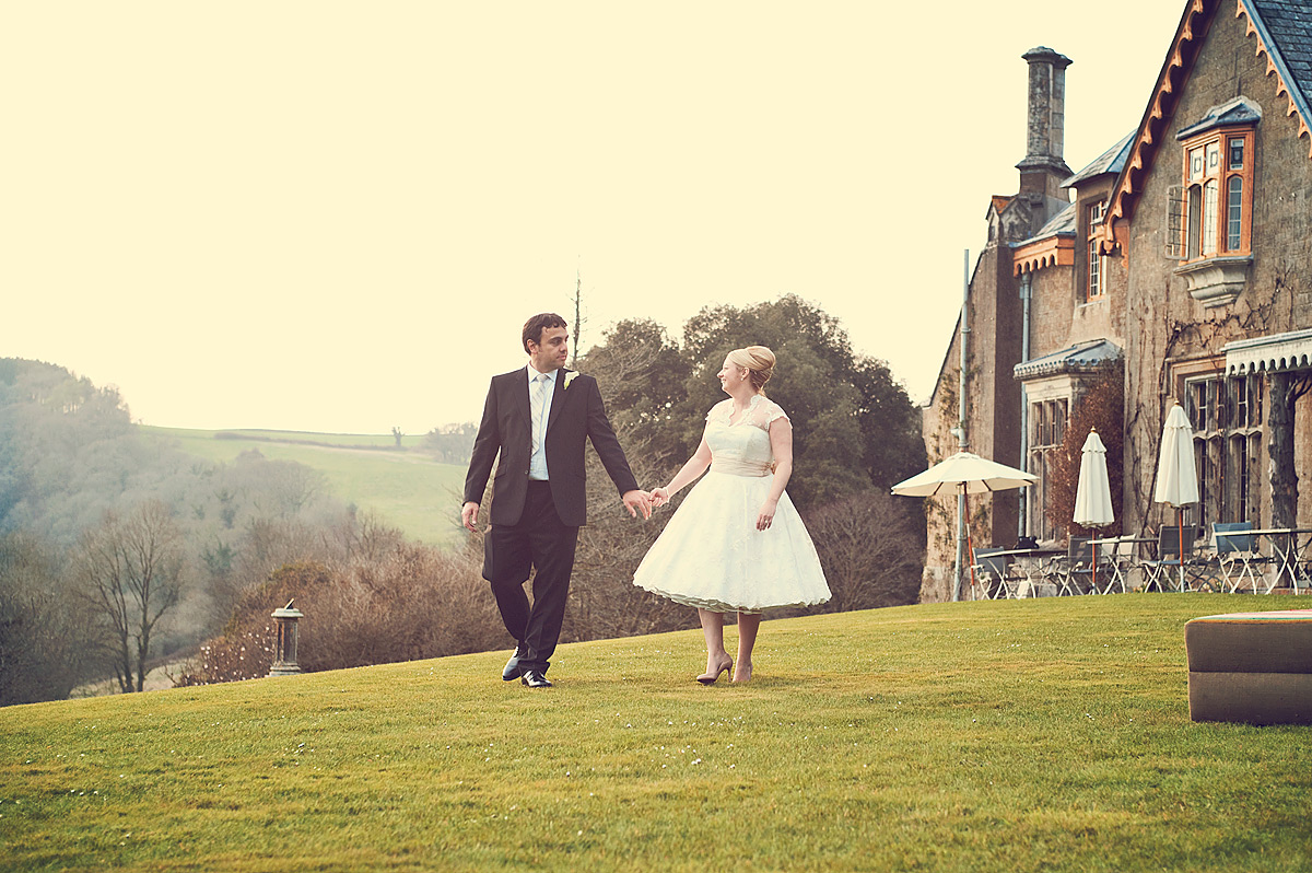 Bride and groom walking on path outside Hotel Endsleigh