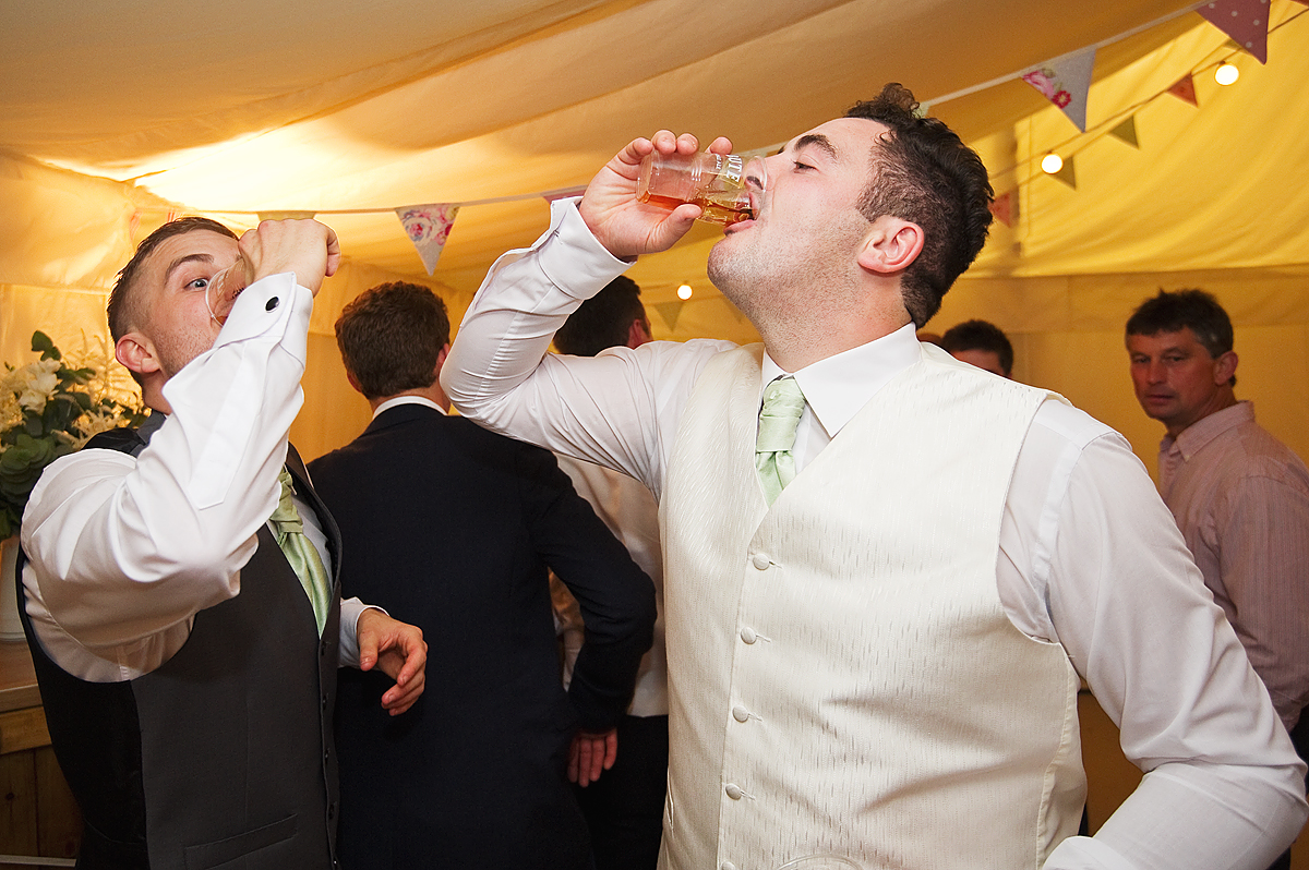 Groom and best man have a shot of booze