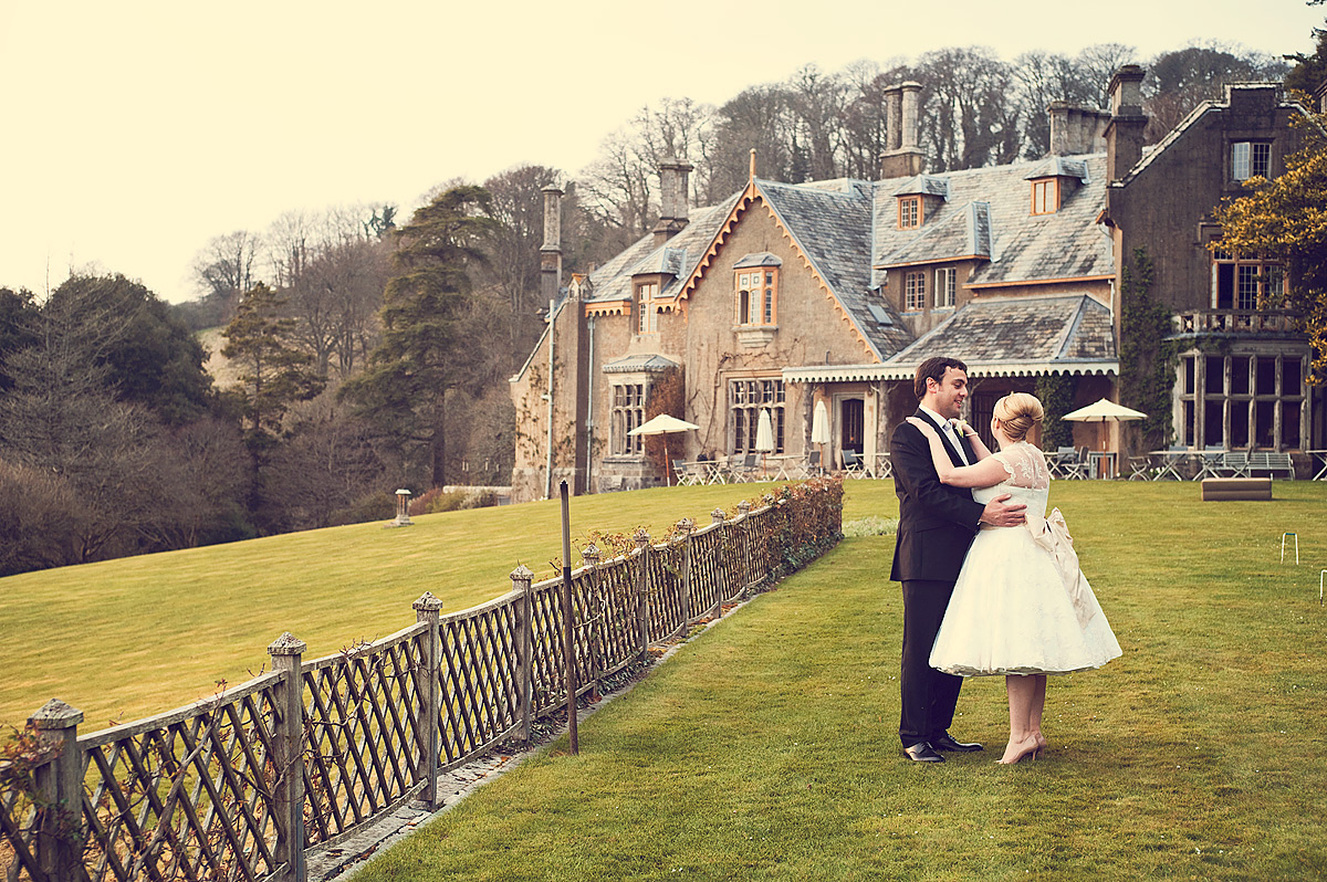 Bride and groom looking into each others eyes in front of Hotel Endsleigh