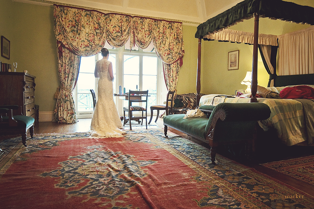 Bride looking out the window at Buckland House waiting for her wedding ceremony