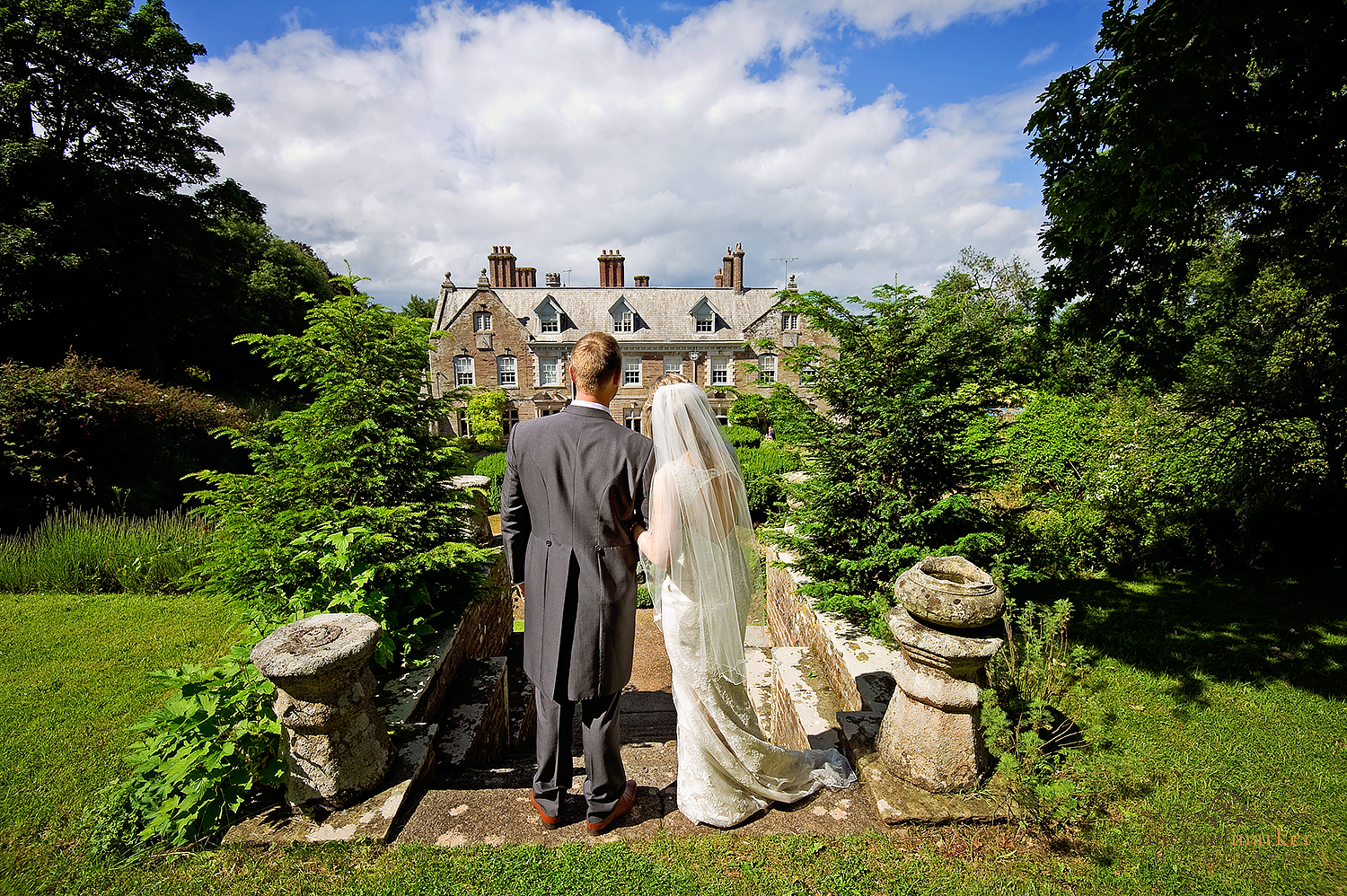 Bride and groom look back towards Langdon Court hotel in Devon