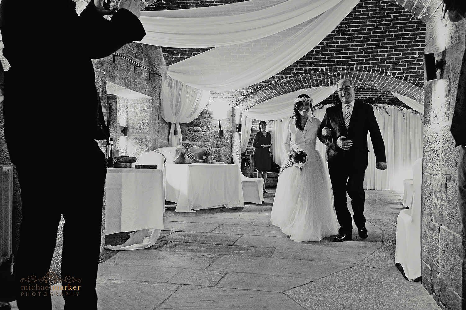 Bride and father walking down the aisle inside Polhawn Fort