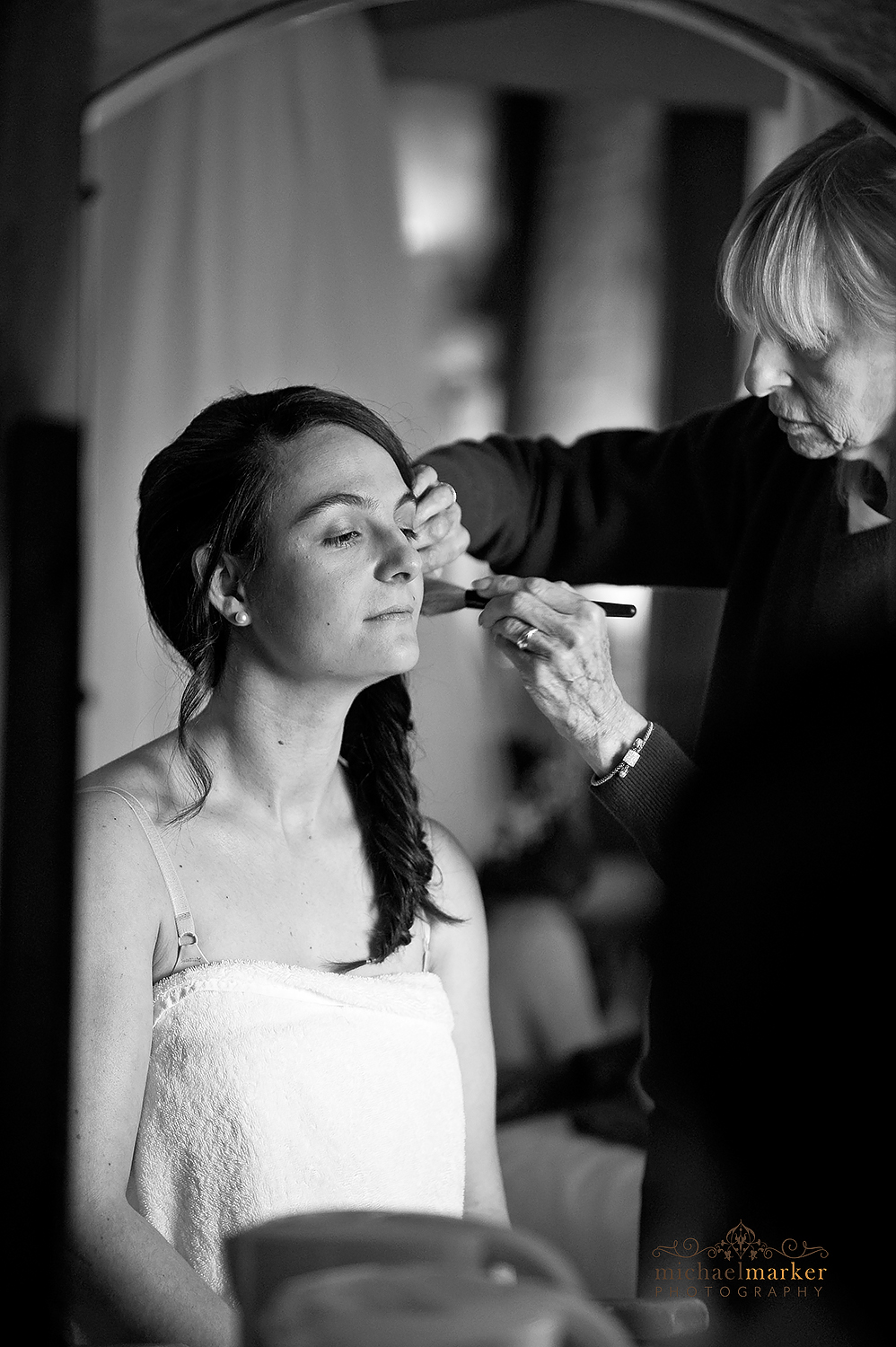 Applying blusher to bride in black and white