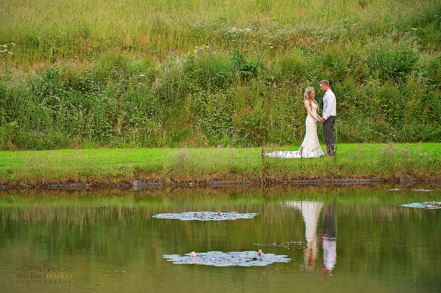 Bride and groom by the lake at Langdon Court in Devon