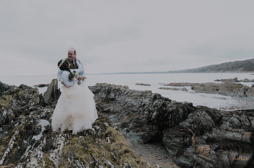 Couple kiss on beach at Polhawn Fort wedding vintage themed