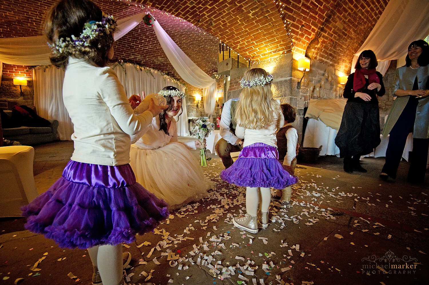 Flower girls and bride with confetti inside Polhawn fort