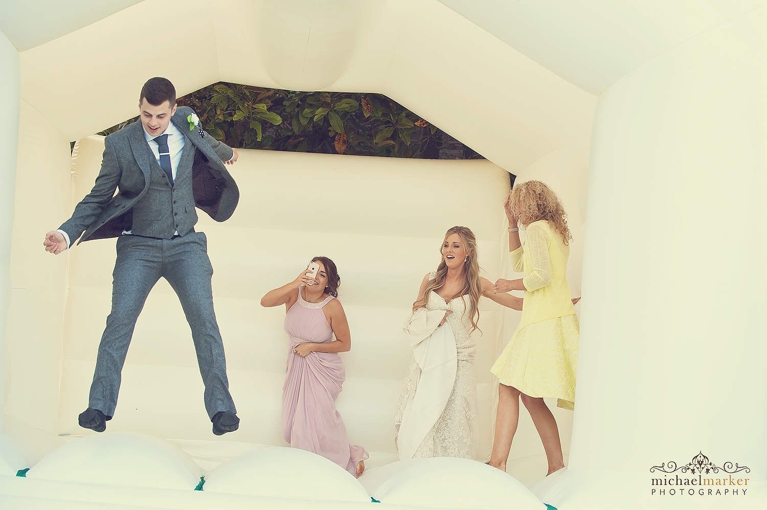 wedding guests jumping on bouncy castle