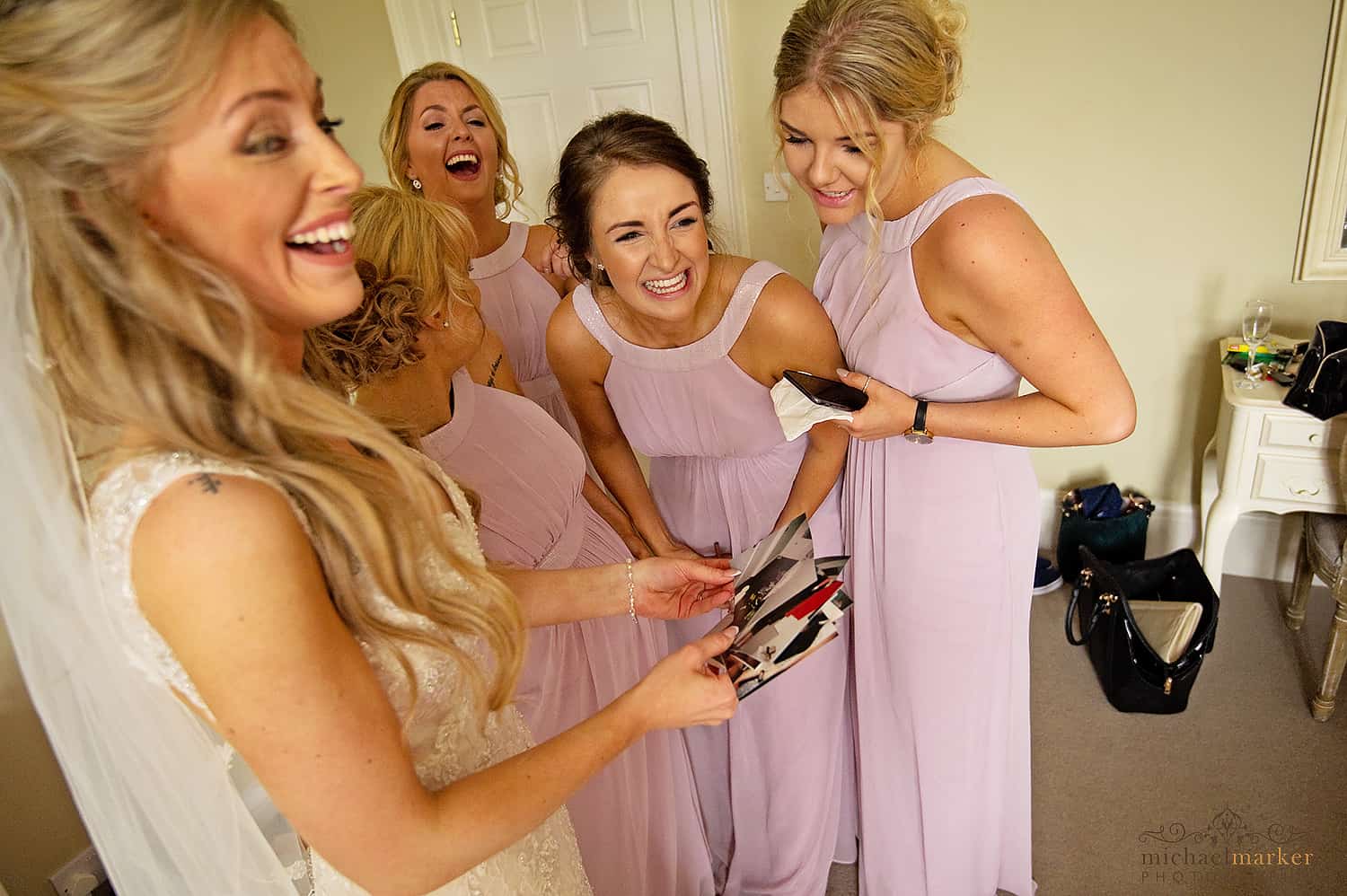 Bride and bridesmaids laughing at hen do photos