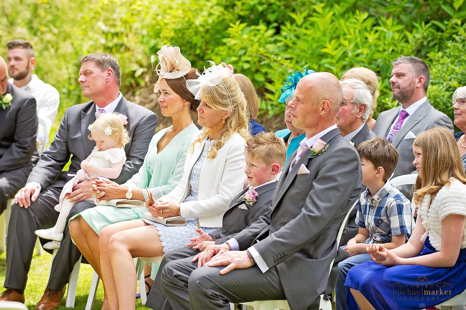 Guests watching a summer outdoor wedding ceremony at Langdon court