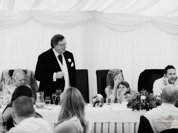 Funny Father of the bride speech by Devon wedding photographers as groom and bride show they are embarrassed