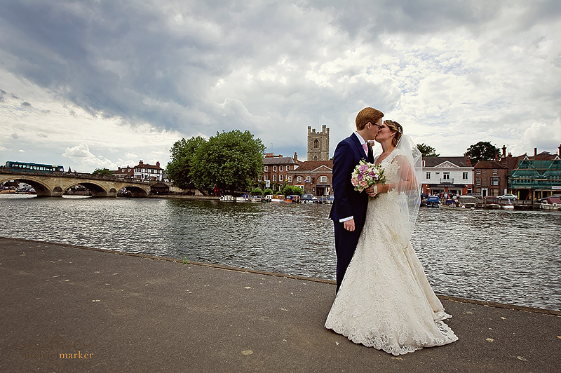 Bride and groom kiss by the River at Henley-on-Thames