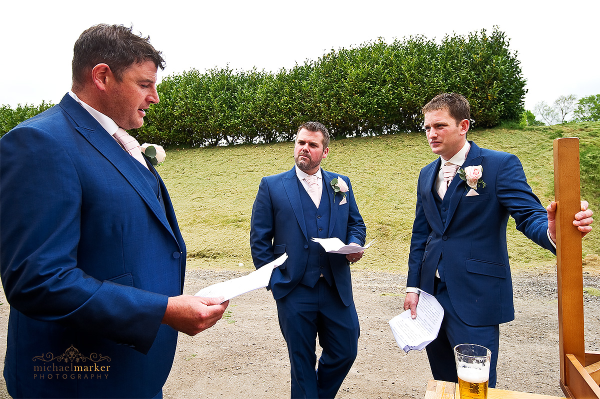 Documentary photo of bestmen preparing their wedding speeches outside before the wedding reception