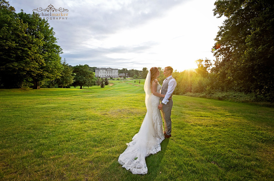 Bride and groom at sunset looking towards Moor Park