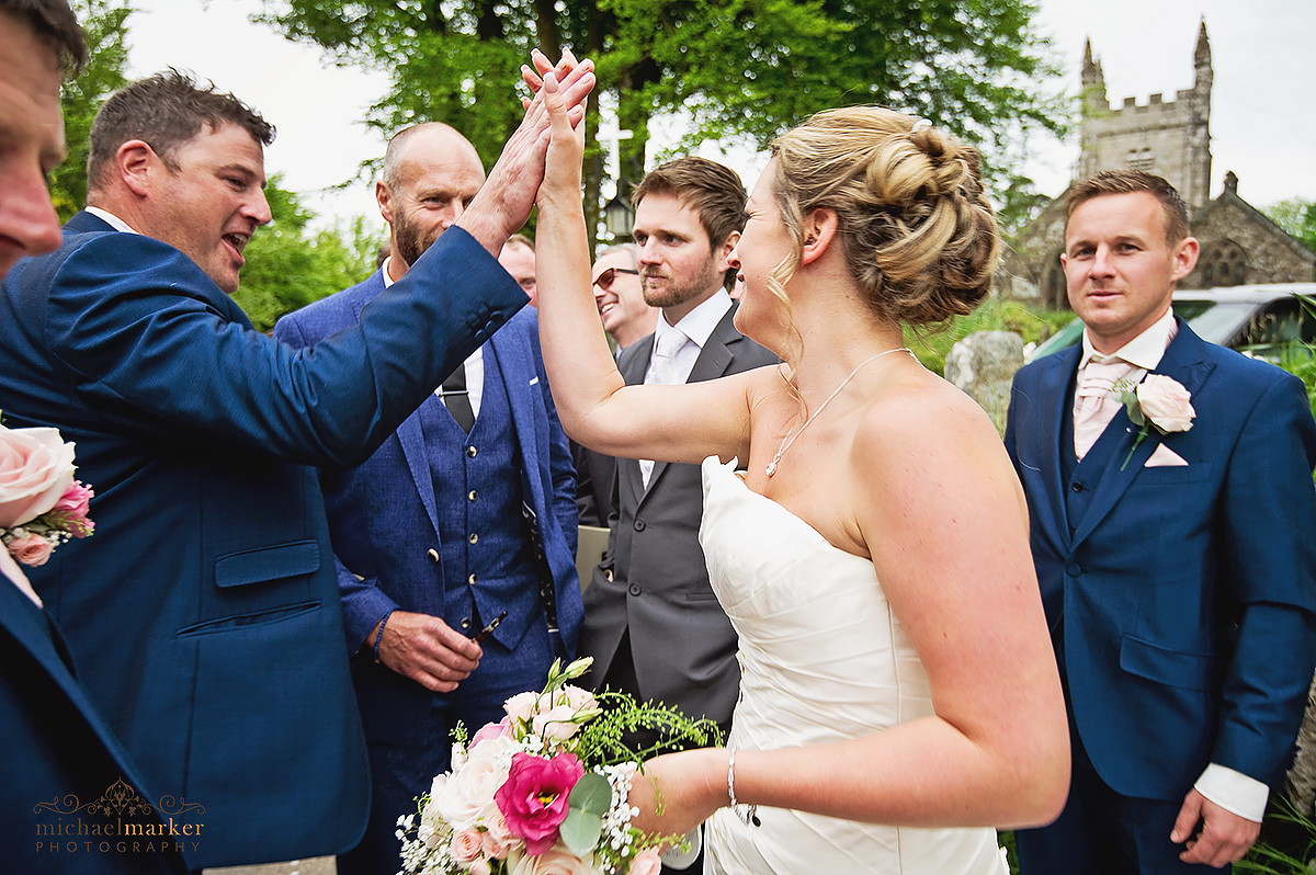 Documentary wedding photo of bestman congratulating bride with high five