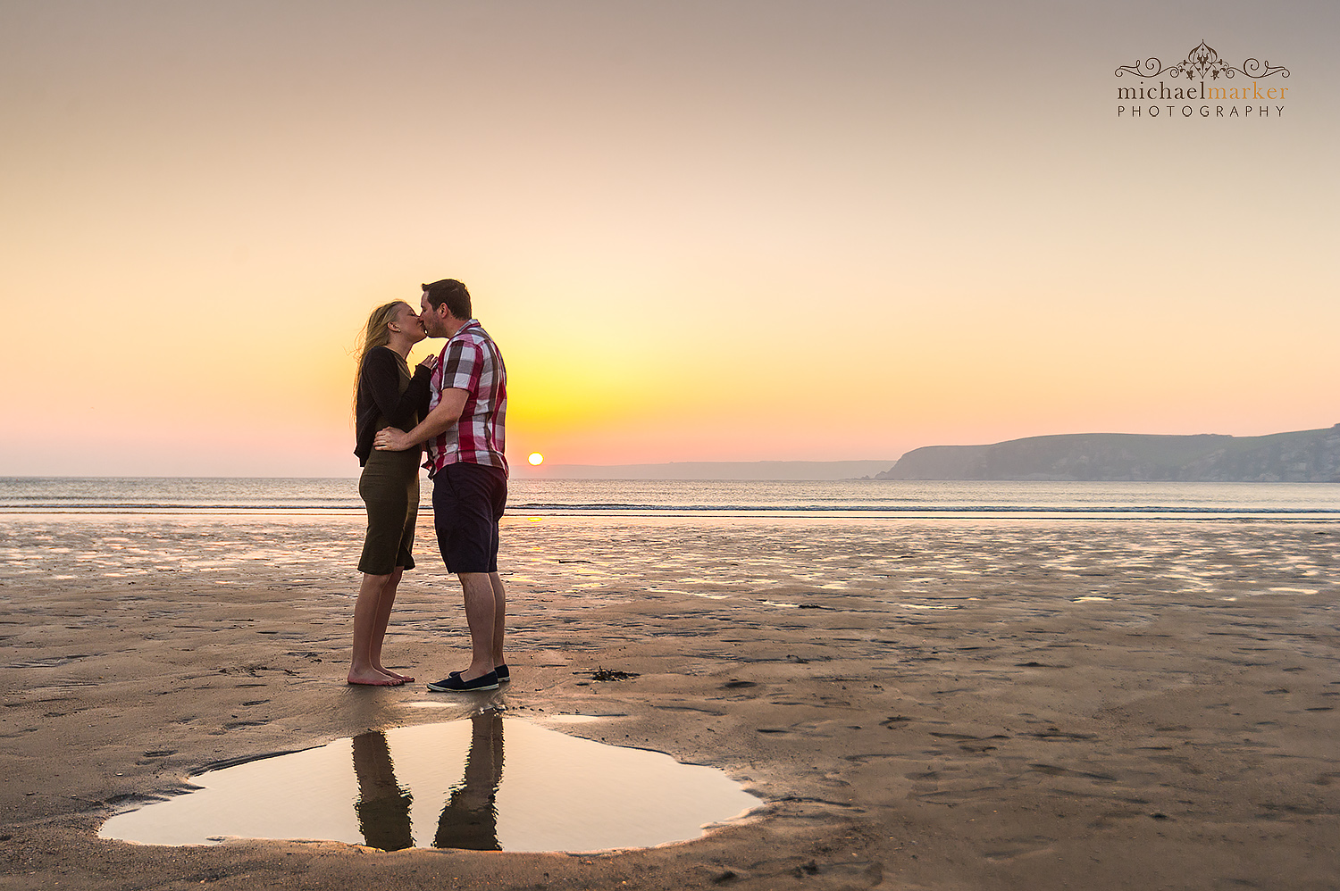 Engagement session on sunset Devon beach at Bigbury. Couple kissing at sunset