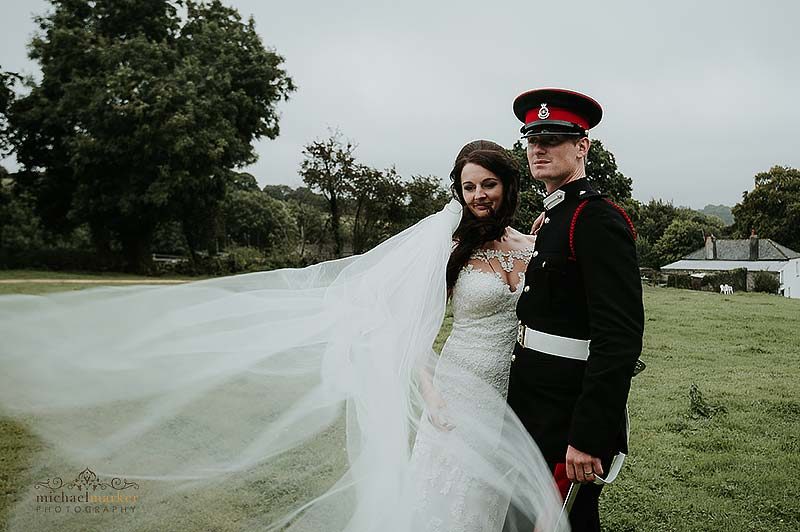 Brides veil blows in breeze during Cornish military wedding