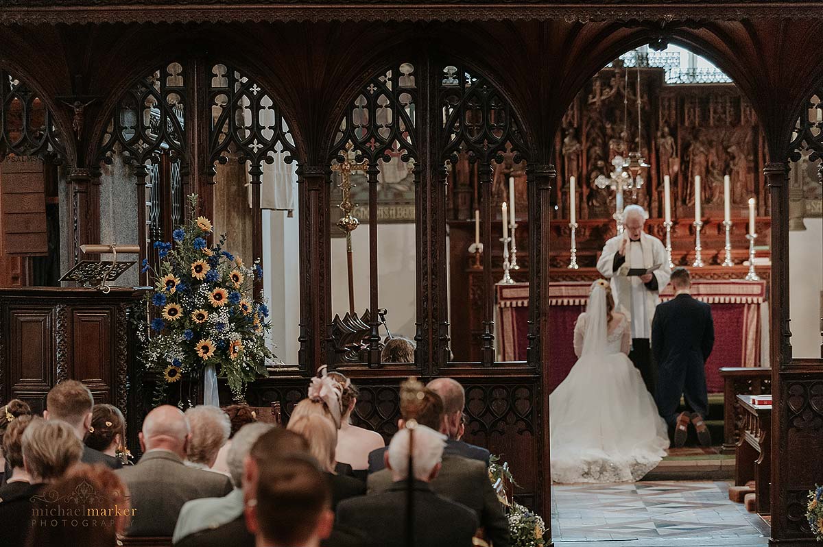 Bride and groom kneeling at altar in Plympton Church in Devon.