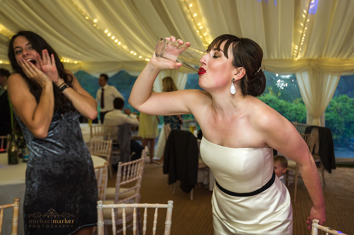 Bride downing a pint of beer at Pentillie wedding marquee