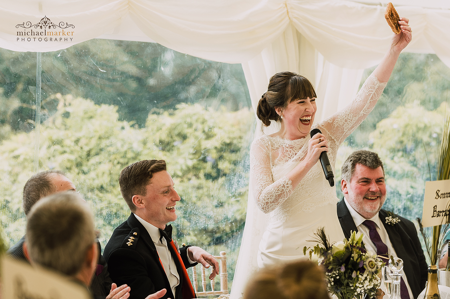 Bride holds piece of toast during her wedding speech at Pentillie Castle wedding