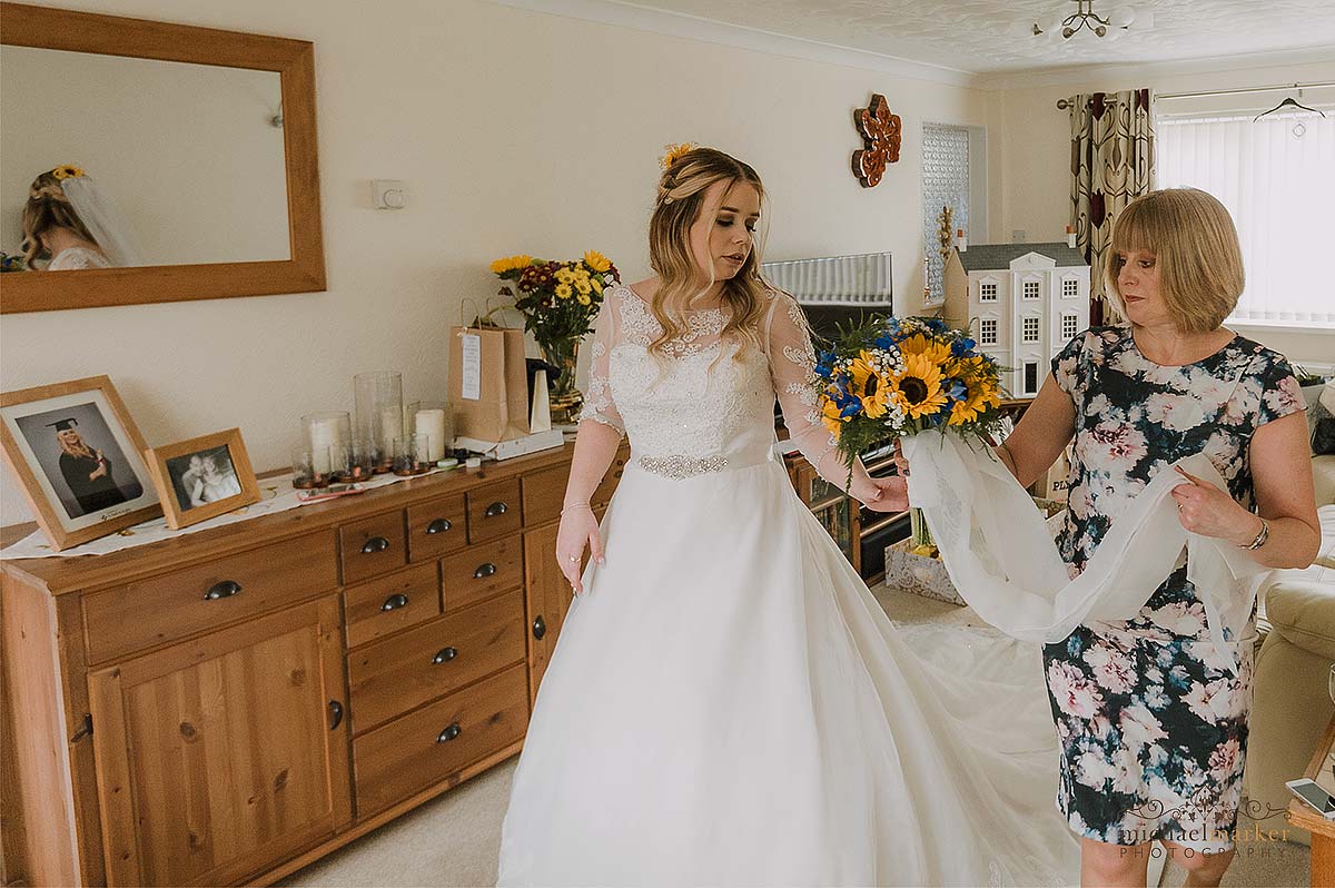 Bride and mother in lounge with veil ready to go on.