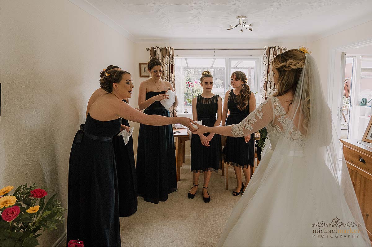 bride and bridesmaids passing tissues to wipe tears.