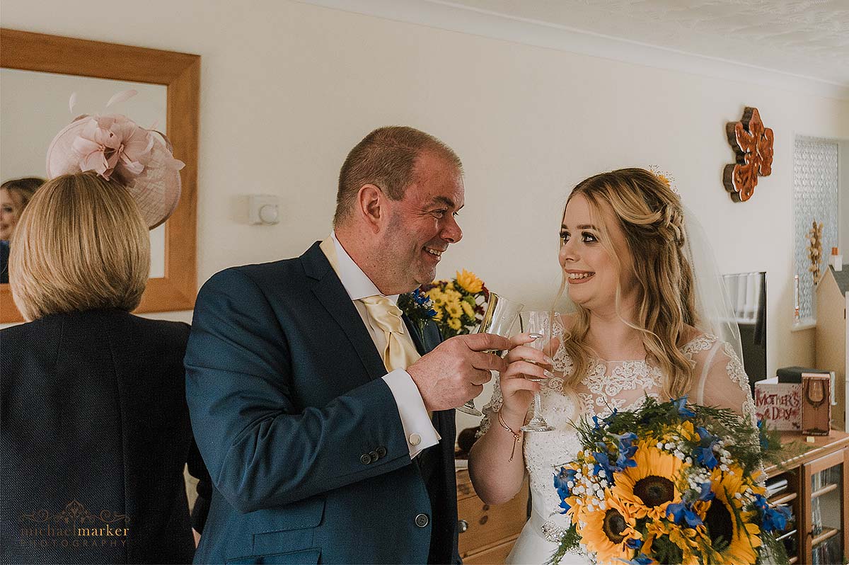 emotional father and bride looking at each other and toasting bucks fizz