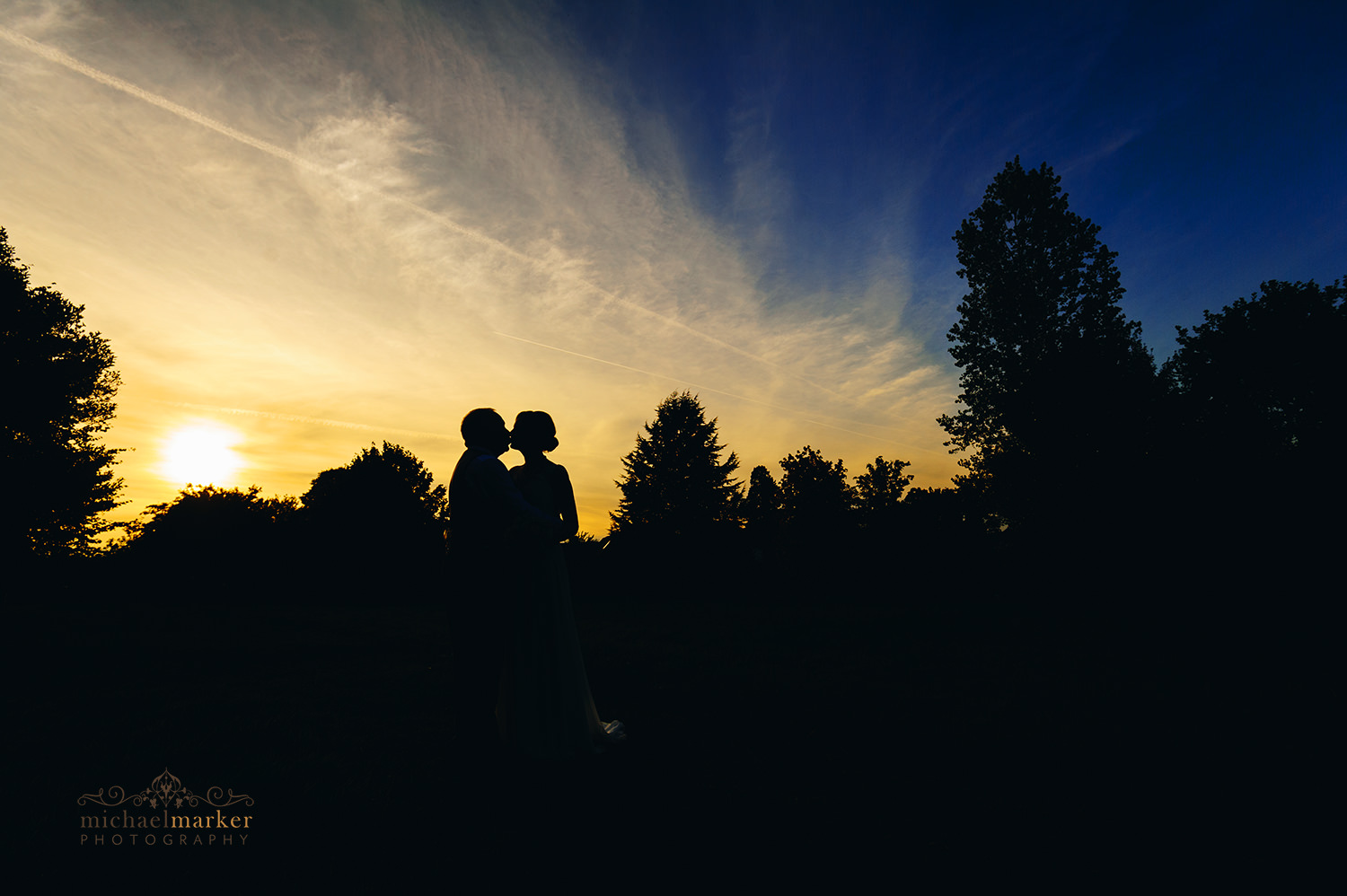 Silhouette of bide and groom kissing at Sunset at Buckinghamshire wedding.