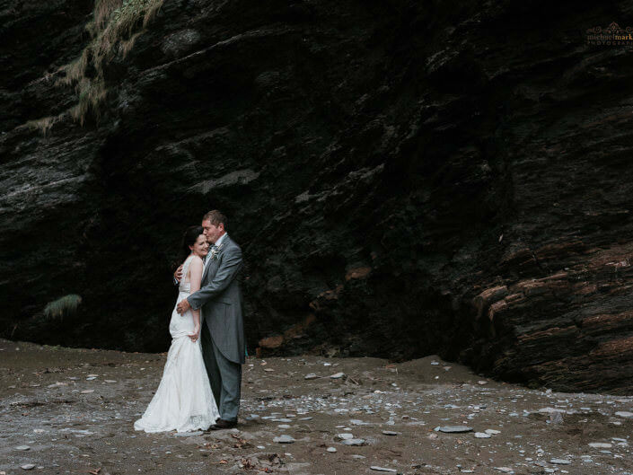 Bride and groom kiss on secluded North Devon beach at their Autumn beach wedding.