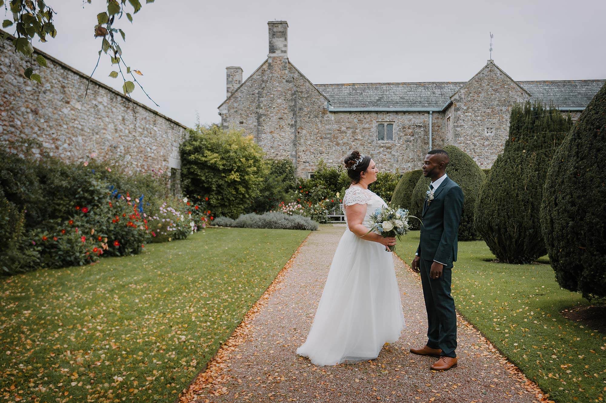 Bride and groom in front of Cadhay House in Devon