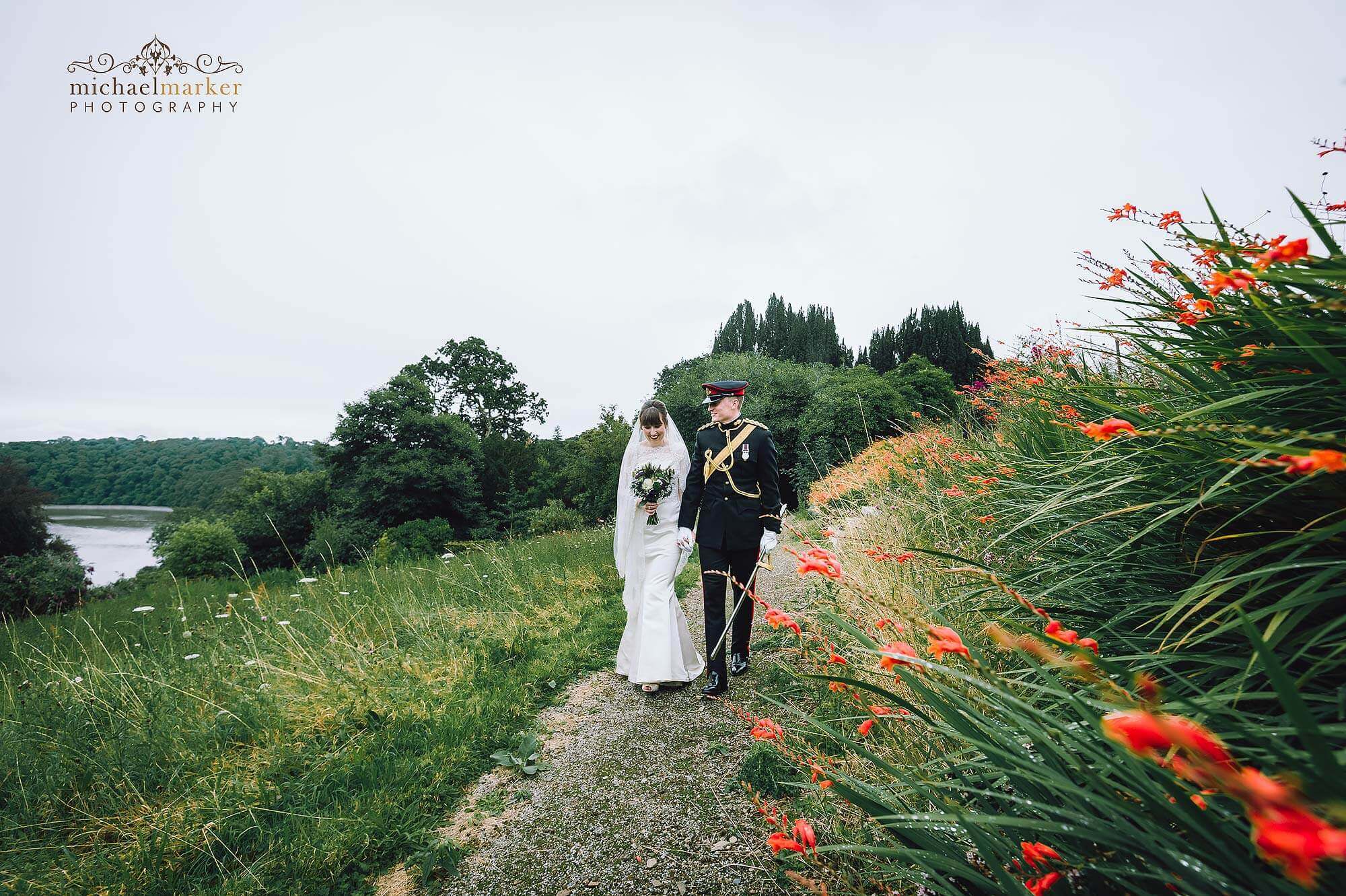 Bride and groom walk in the gardens of luxury Cornish wedding venue Pentillie Castle.