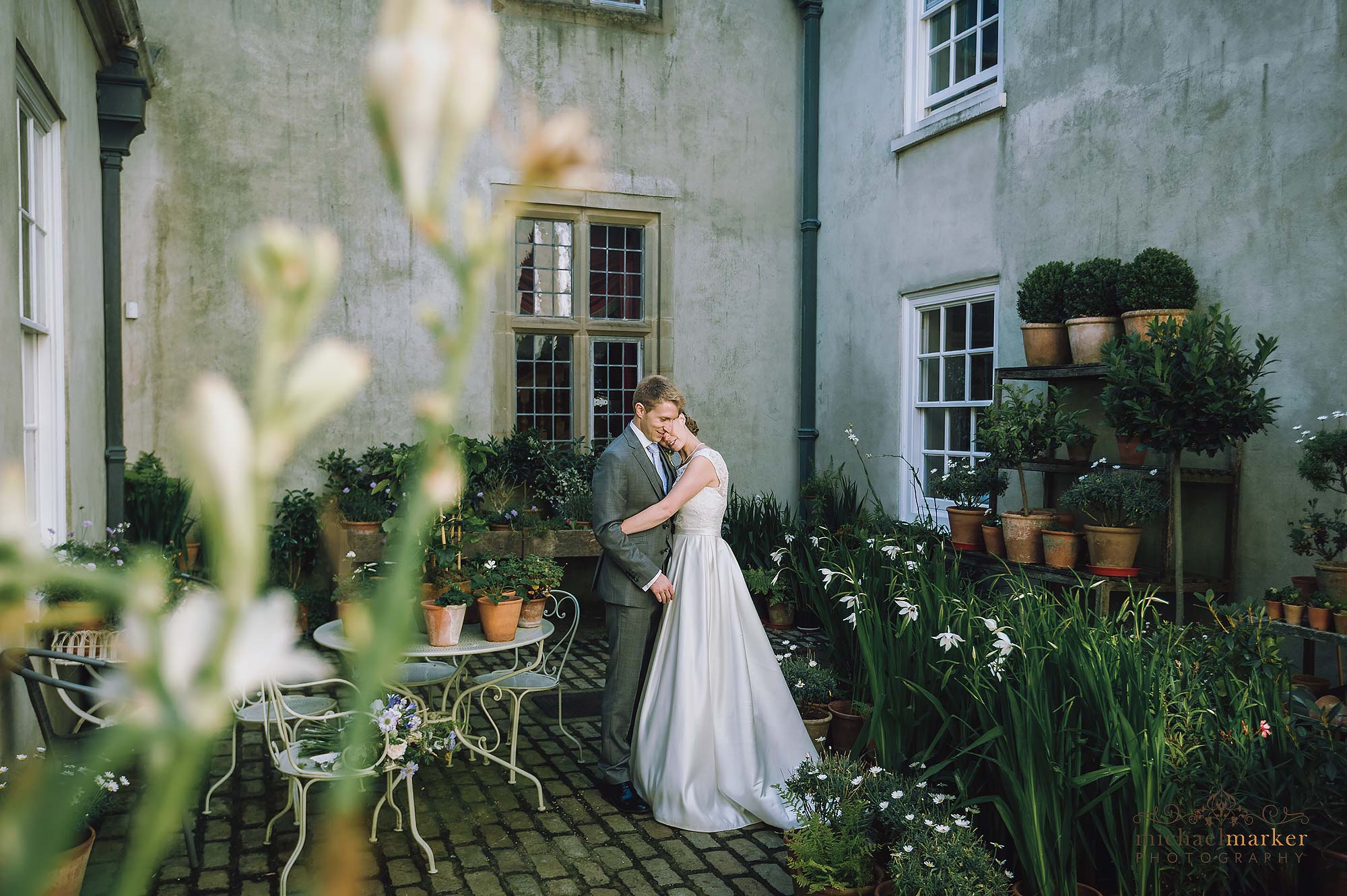 Bride and groom tender moment in the courtyard of luxury Devon wedding venue Shilstone Country House.