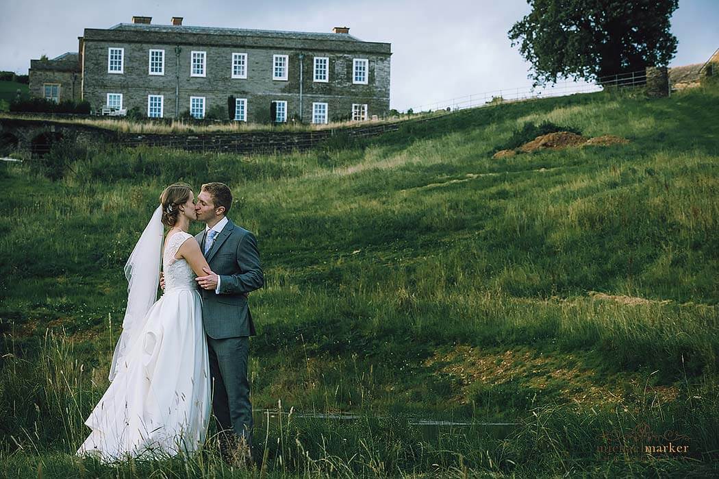 tender-wedding-kiss-in-fields-at-Shilstone-House