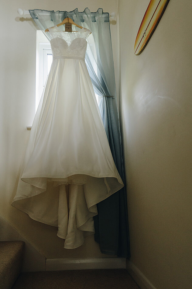 Devon brides wedding dress hanging on the staircase