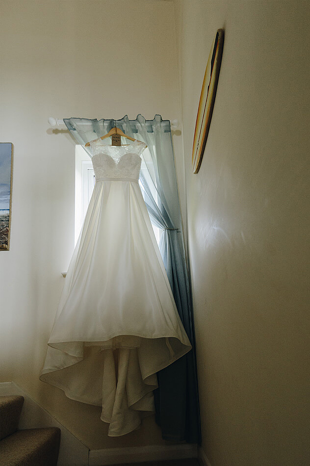 Brides wedding dress hanging up on the stairs in devon