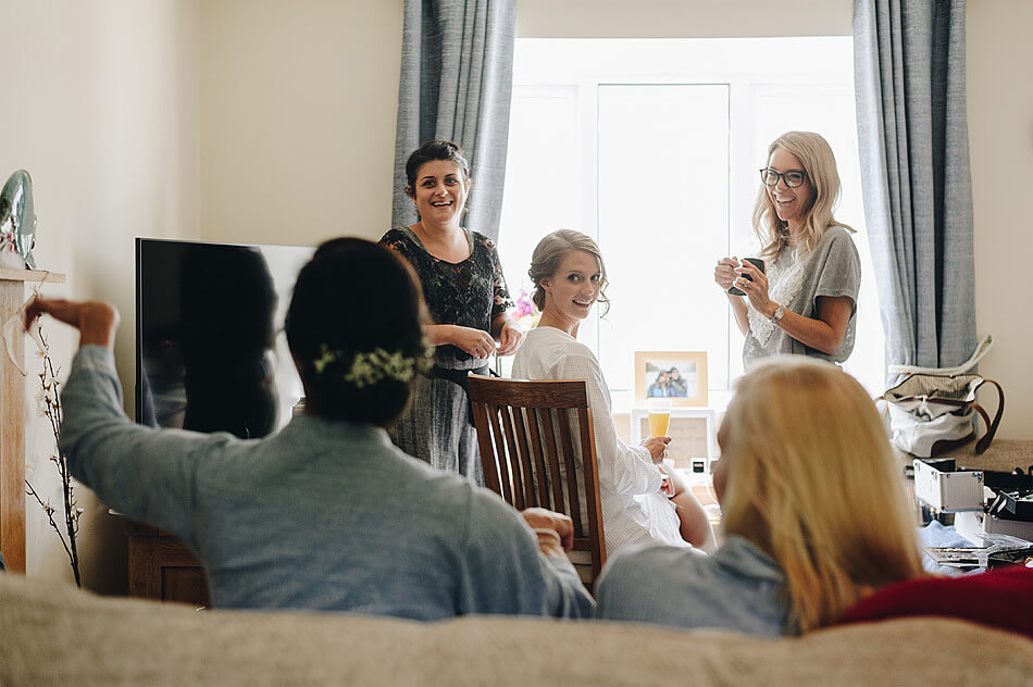 brde looking at bridesmaids before her Devon wedding 