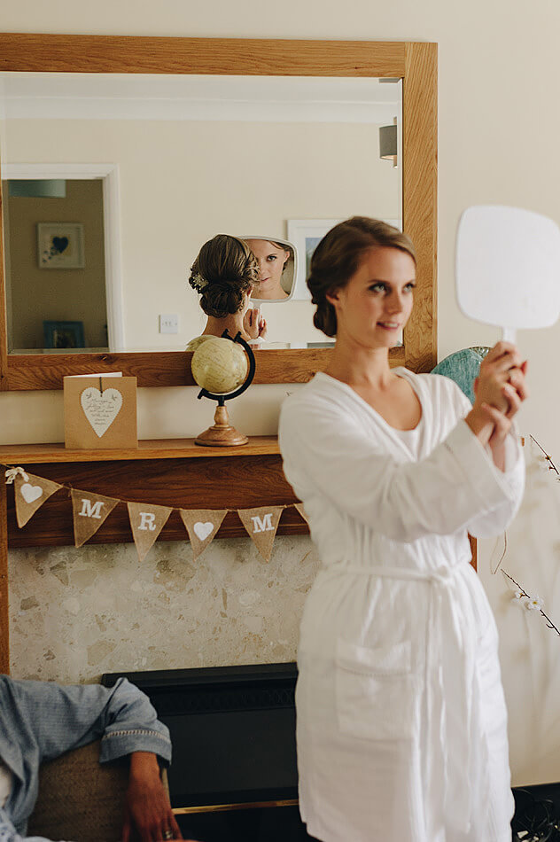 Bride looking at her hairstyle in the mirror